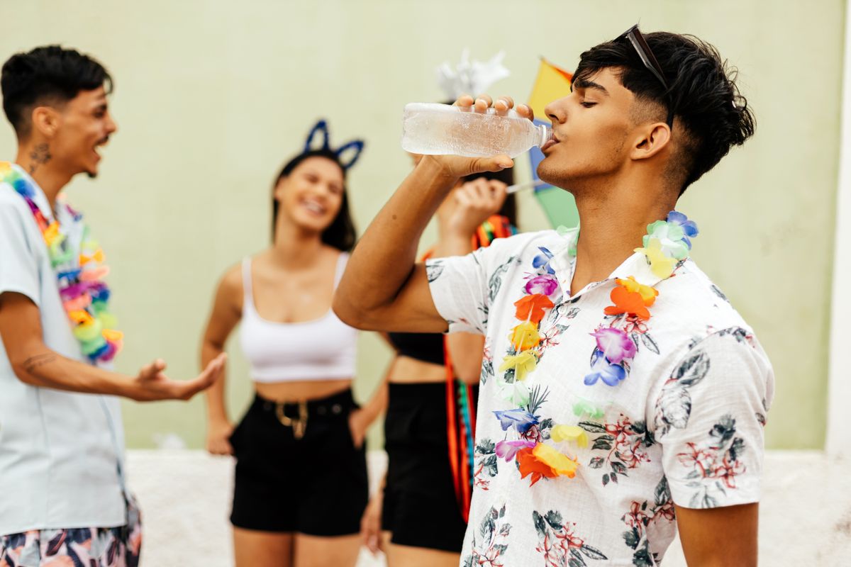 Brazilian,Carnival.,Person,Drinking,Water,During,Carnival,Block,On,The