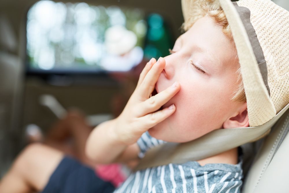 Boy,Holds,The,Hand,Over,His,Mouth,While,Yawning,On