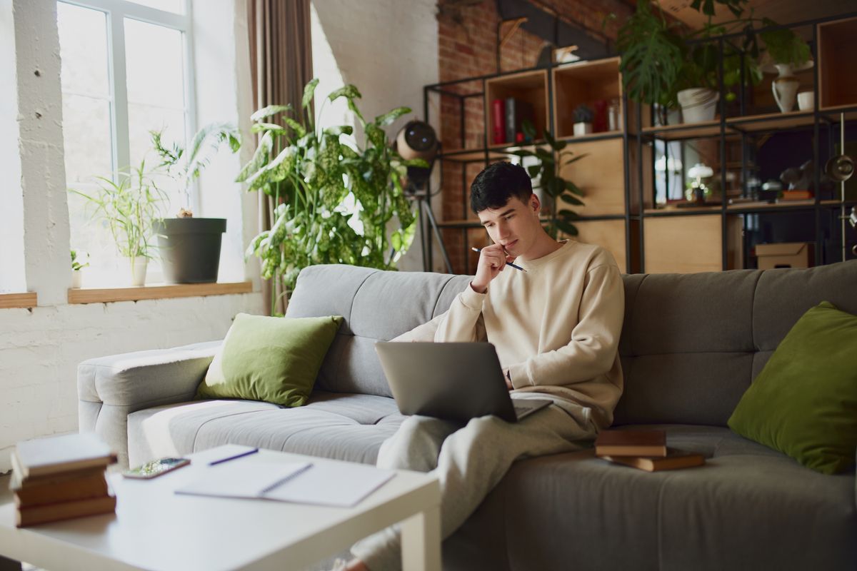 Home,Study,Session.,Young,Man,,Student,Comfortably,Sitting,On,Grey